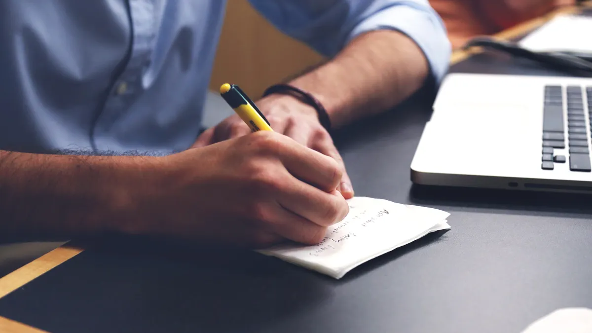 How to automate repetitive writing tasks with templates and variables — Person Writing on Paper Using Yellow and Black P